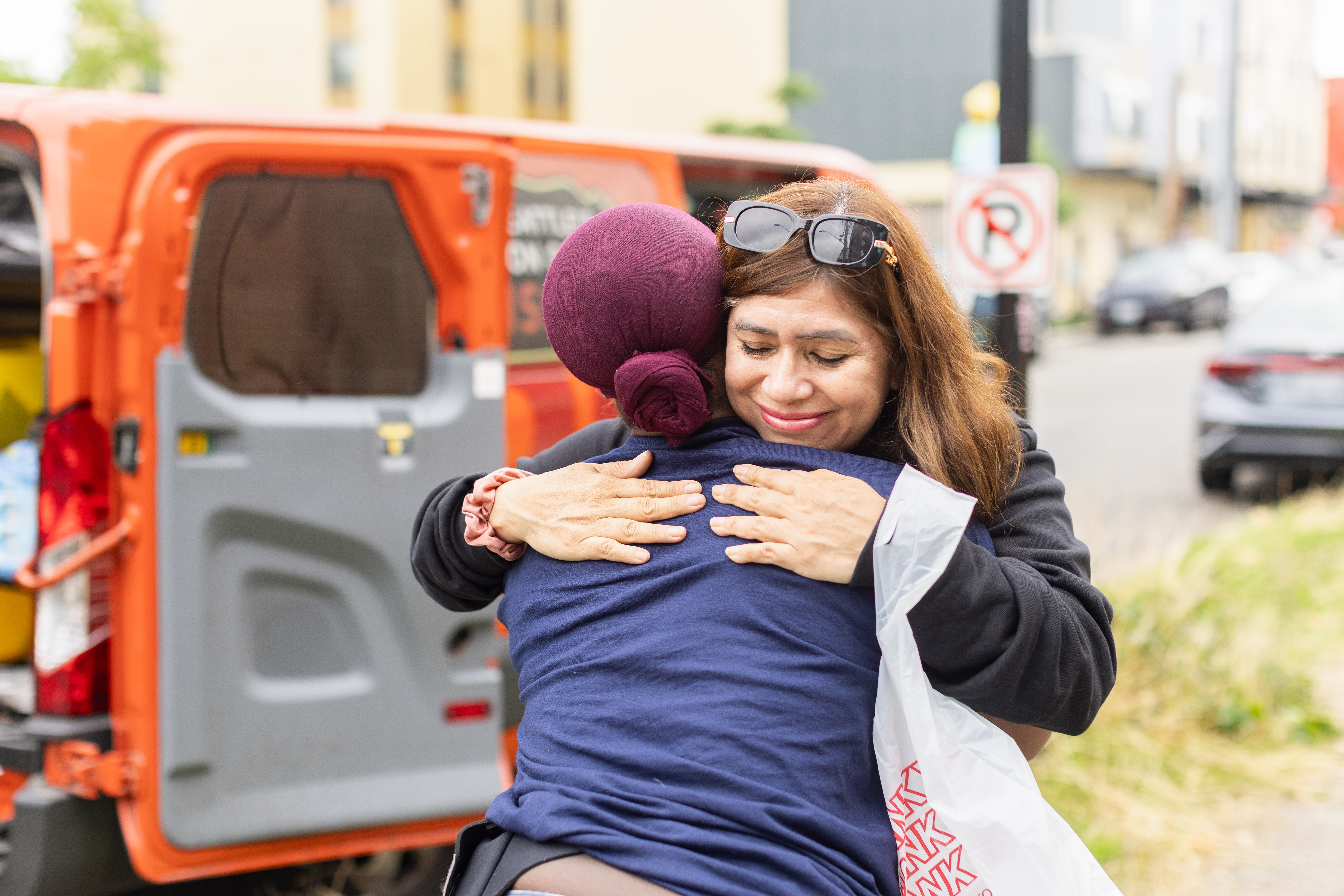 Search + Rescue member hugging  a woman in need